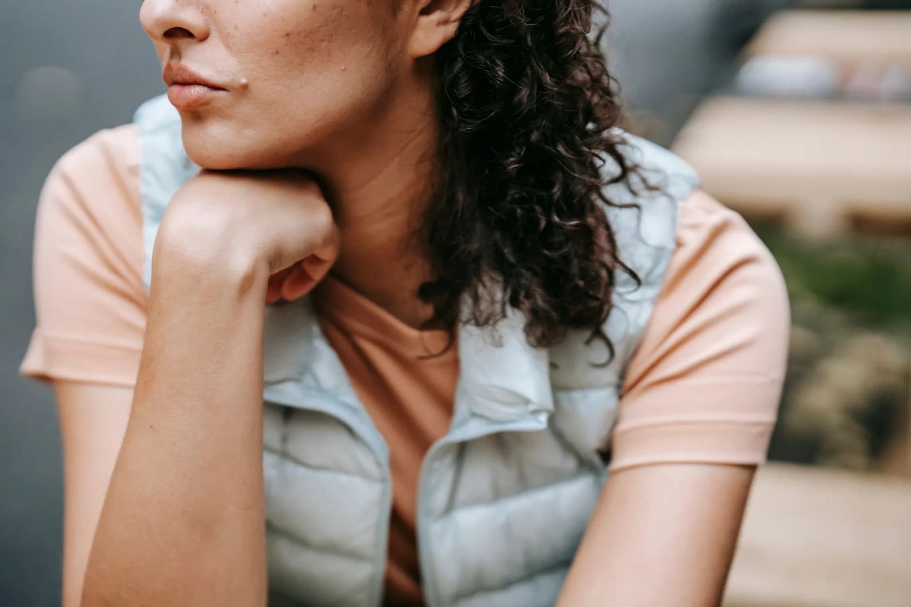 Crop faceless curly haired female holding hand on chin while sitting in park · Фото: Sam Lion / Pexels